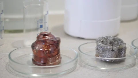 Close-up of scientist's hand taking one of the minerals on the table and putting Stock Footage 105706359