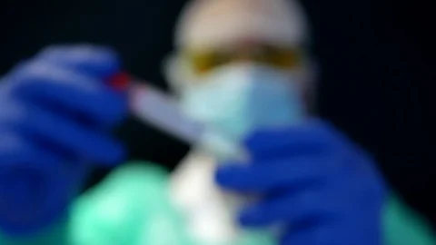 Close up of scientist's hands wearing nitrile gloves holding a sample tub wit Stock Footage 127638927
