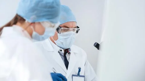 Close up. scientists in protective masks work in the laboratory. Stock Photos