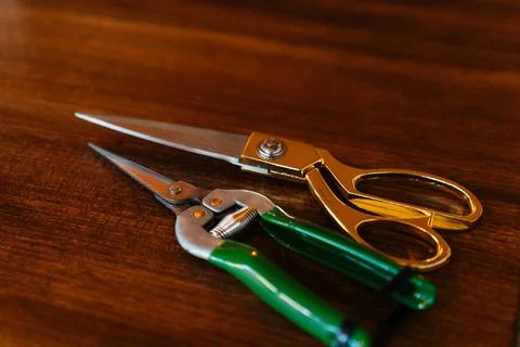 Close-up of scissors and pruning shears on a wooden surface, highlighting sharp Stock Photos