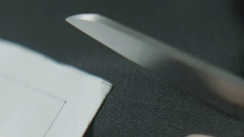 Close up of scissors cutting fabric along paper pattern Stock Footage 124244342