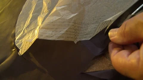 A Close-up of scissors cutting fabric around a sewing pattern Stock Footage 311927604