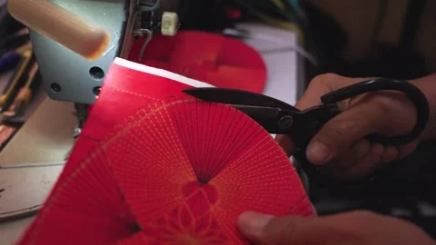Close-up of scissors cutting red fabric for a songkok top panel in Malaysia Video stock 333134238