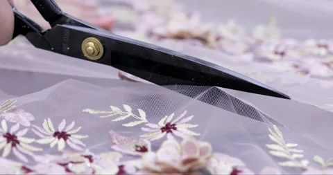 Close-up scissors cutting transparent fabric ceiling patterns colored flowers. Stock Footage 237328993