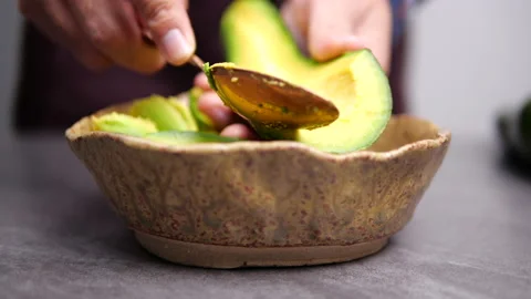 Close-up of Scooping avocado with spoon for cooking healthy vegetarian food. Stock Footage 135777535