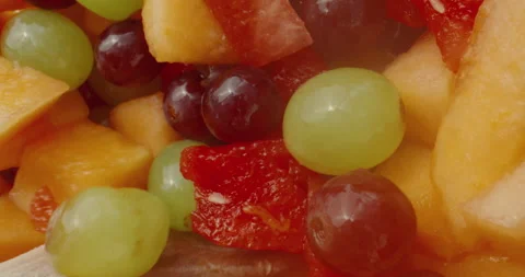 Close-up scooping a spoonful of fresh fruit, cantaloupe, watermelon, grapes Stock Footage 138136083