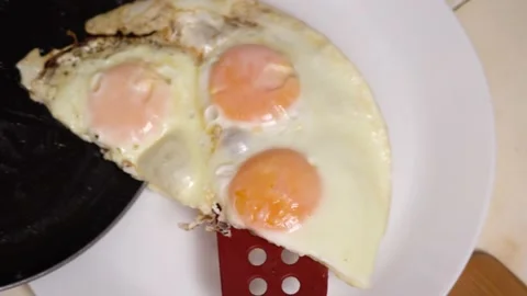 Close up. Scrambled eggs from frying pan put on plate. Stock Footage 142216337