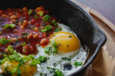 Close-up of scrambled eggs with red beans in a frying pan. English breakfast in Stock Photos