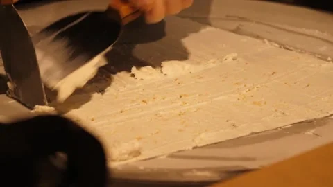 Close-up of Scraper Chopping and Preparing Rolled Ice Cream on Cold Plate Video stock 345293095