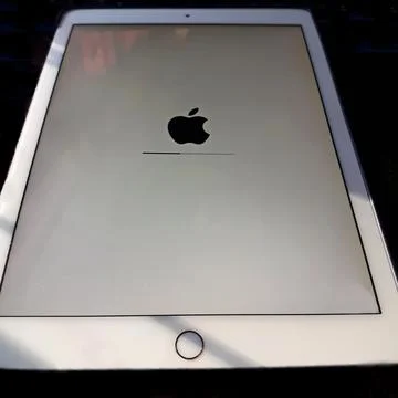 Close-up screen, apple logo on iPad air 2 duriing. Stock Photos
