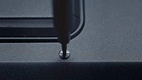 A close up of a screw being screwed into a piece of plastic. Assembling the Stock Footage 265125754