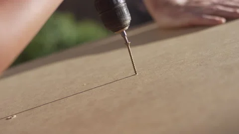 Close-up on a screw getting drove into a piece of wood with a power drill Video stock 132540413