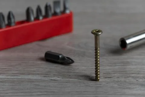 Close-Up of Screwdriver Bits and Screw on Wooden Surface Stock-Fotos