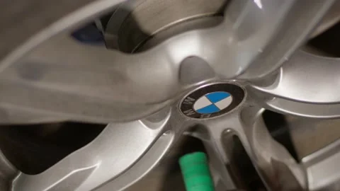 Close-up. A screwdriver tightens a bolt on a cast disc of a BMW car. Video stock 233537289