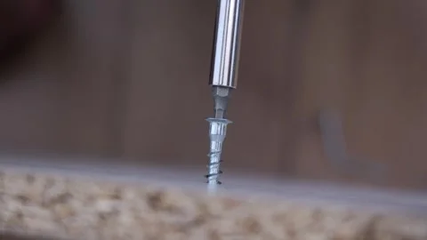 Close-up of the screwdriver twists the confirmation into the chipboard when Stock Footage 302285044