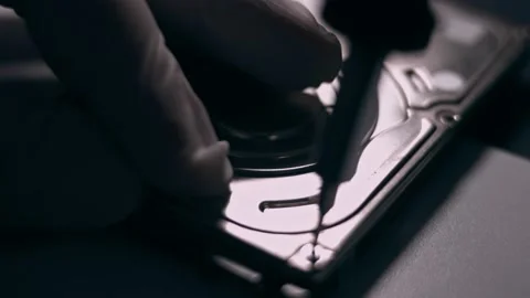 Close-up. Screwdriver unscrews the screw from the computer hard drive. Male 動画素材 144451639