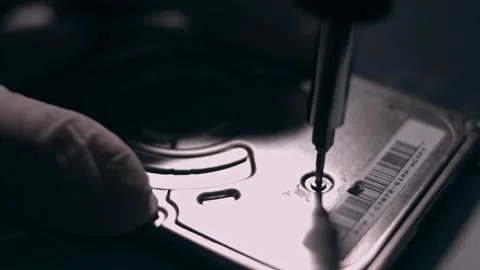 Close-up. Screwdriver unscrews the screw from the computer hard drive. Male 動画素材 144451795