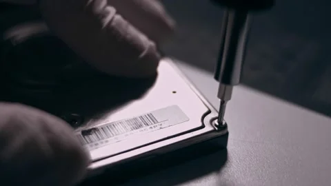 Close-up. Screwdriver unscrews the screw from the computer hard drive. Male 動画素材 144452336