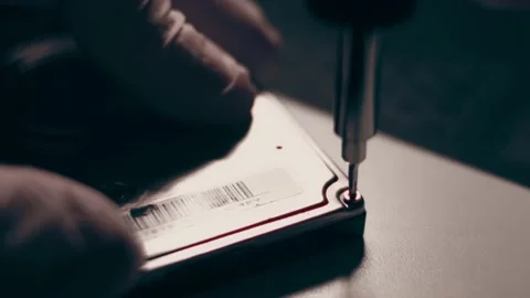 Close-up. Screwdriver unscrews the screw from the computer hard drive. Male 動画素材 233455162