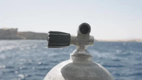 Close up of a scuba diving tank valve on a boat, with the blue sea Видео 333851655
