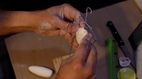 Close up of the sculptor s hands applying clay to the character s metal Stock Footage 260842866