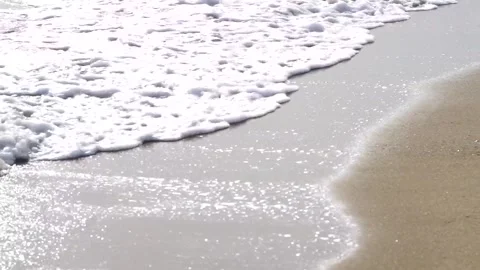Close up of sea surf with beach and reflection on wet sand Vidéo 323345478