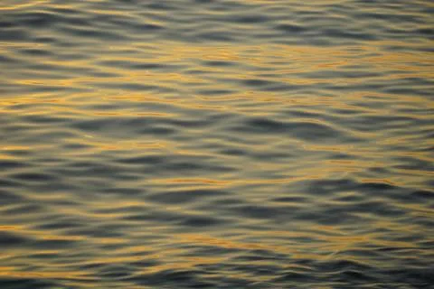 Close up of the sea surface with small waves and sun reflections creating a.. Stock Photos