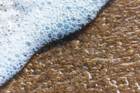 Close up of the sea water affecting the sand on the beach, sea waves calmly Stock Photos