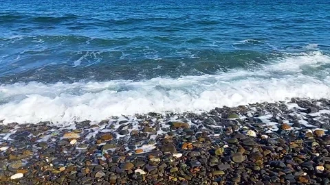 Close-Up of Sea Wave Breaking on a Multi-Colored Pebble Beach Stock Footage 322990456