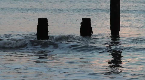 Close Up of the Sea, Waves Break Against Wooden Posts in Sunset Light Stock-Footage 46360716
