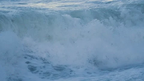 Close Up of Sea Waves Breaking onto Beach in Slow Motion with Sun Reflection on Stock Footage 297368208