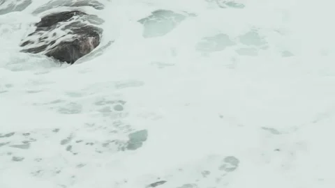Close-up of sea waves breaking on rocks. White sea foam bubbles on the surface Stock Footage 178396030