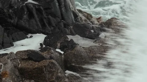 Close-up of sea waves breaking on rocks. White sea foam bubbles on the surface Stock Footage 178397163