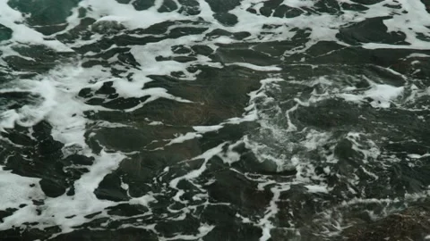 Close-up of sea waves breaking on rocks. White sea foam bubbles on the surface Stock Footage 178397502