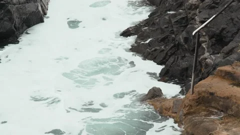 Close-up of sea waves breaking on rocks. White sea foam bubbles on the surface Stock Footage 178397843