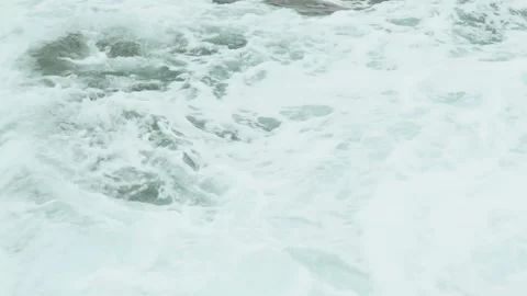 Close-up of sea waves breaking on rocks. White sea foam bubbles on the surface Stock Footage 178399734