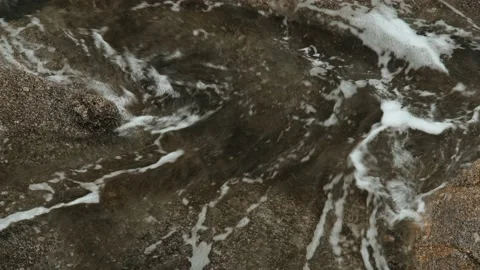 Close-up of sea waves breaking on rocks. White sea foam bubbles on the surface Stock Footage 178400174