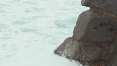 Close-up of sea waves breaking on rocks. White sea foam bubbles on the surface Stock Footage 178955537