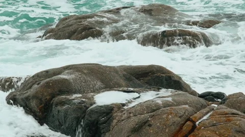 Close-up of sea waves breaking on rocks. White sea foam bubbles on the surface Stock Footage 185547316