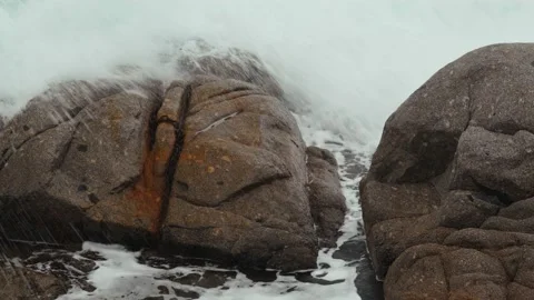 Close-up of sea waves breaking on rocks. White sea foam bubbles on the surface Stock Footage 185549607