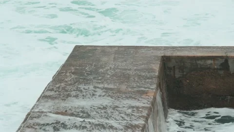 Close-up of sea waves breaking on stone breakwater. White sea foam bubbles on Stock Footage 178398228