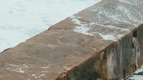 Close-up of sea waves breaking on stone breakwater. White sea foam bubbles on Stock Footage 178399316