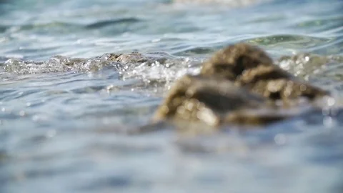 Close up of sea waves spilling over small rock in slow motion Vídeo Stock 84802732