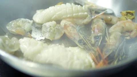 Close-up of seafood fried in a frying pan in hot oil. A professional chef cooks Stock Footage 167243719