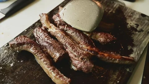 Close-Up of Seared Beef Strips on Wooden Cutting Board with Glossy Texture Stock Footage 340954849