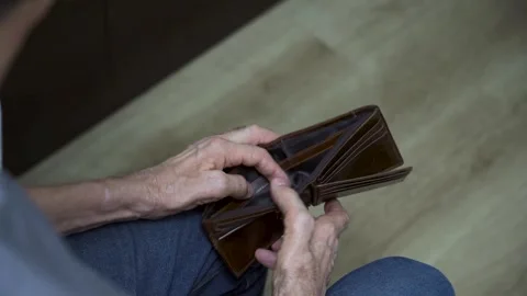 Close-up of seated senior opening empty wallet slowly Stock Footage 307402761