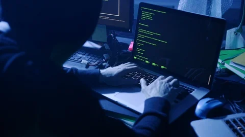 Close-up of secret hooded computer hacker typing data codes on laptop in the Stock Footage 108820234