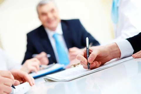 Close-up of secretary hands over document with her boss on background Stock Photos