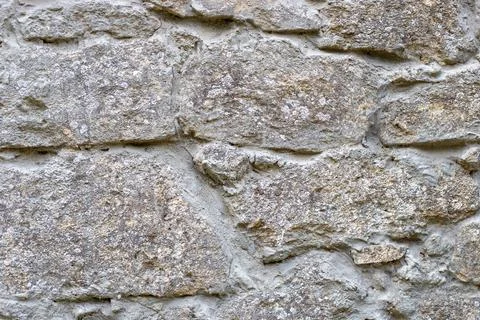 Close-up of a section of masonry with gray, uneven stones held together with 스톡 사진