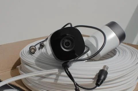 Close-up of a security camera with a roll of wire, ensuring surveillance an.. 库存照片